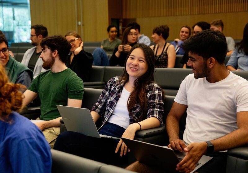 A group of University of Cambridge students listening to a lecture and talking. Copyright University of Cambridge (June 2023)