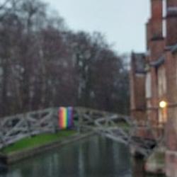 A rainbow flag hangs over the river Cam